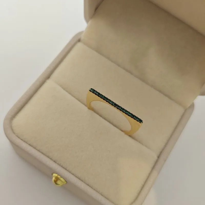 anel com pedra verde e caneta negra